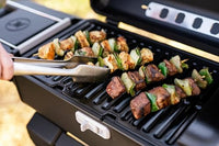 Pinchos de carne y verduras asándose en la parrilla portátil