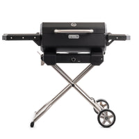 Parrilla asador portátil Masterbuilt a carbón sobre su carrito plegable de patas cruzadas y ruedas