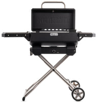 Parrilla portátil Masterbuilt con la tapa abierta sobre el carrito plegable