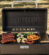 Tapa abierta de la parrilla portátil con chorizos y verduras sobre las rejillas