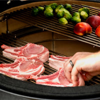 Chuletas de cerdo y verduras sobre la parrilla del Kamado Joe
