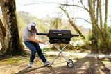Hombre desplegando el carrito de la parrilla portátil al aire libre