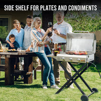 Familia compartiendo en la mesa junto al asador ONLYFIRE GS308 con mesa lateral para platos
