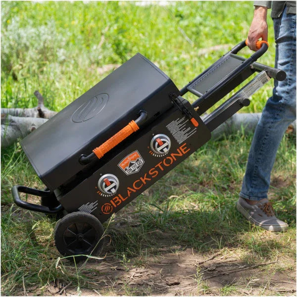 Hombre transporta plancha Blackstone portátil con soporte plegable para asados y bbq
