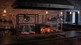 Parrilla argentina doble para restaurante en cocina abierta bajo campana con brasas encendidas