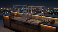 Parrilla doble con brasero central en cocina exterior de terraza de noche